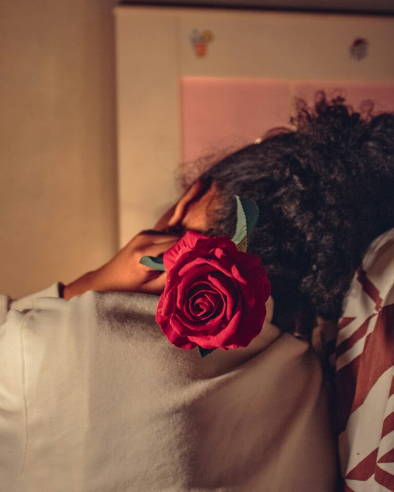 A woman holding a rose behind her back as a visual representation of grieving on Valentine's Day.